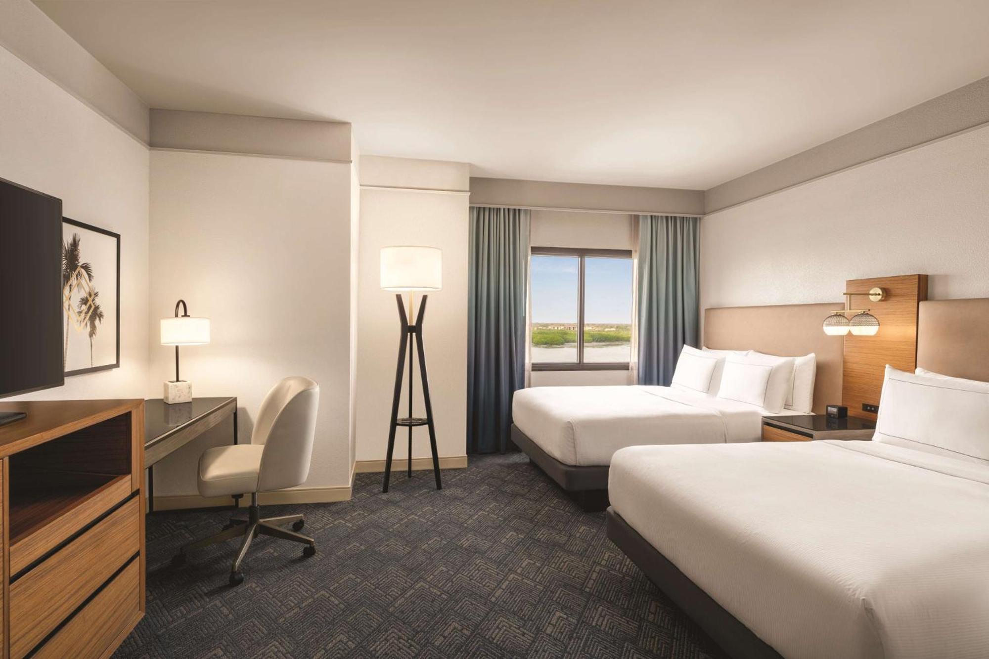 Zimmer mit 2 Queensize-Betten sowie Bucht- und Poolblick