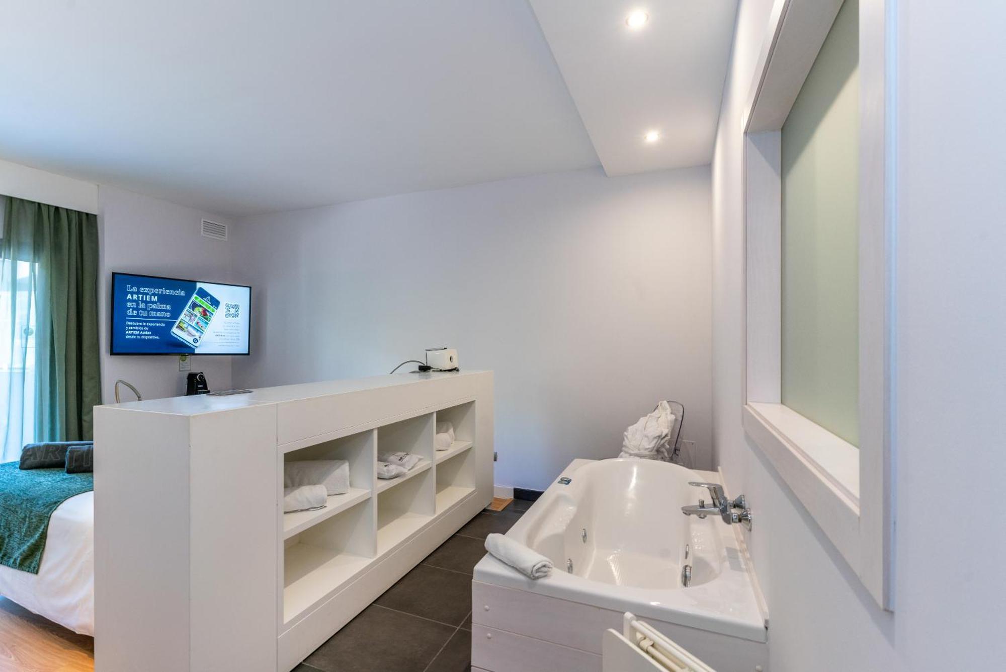 Habitación con cama grande y bañera de hidromasaje